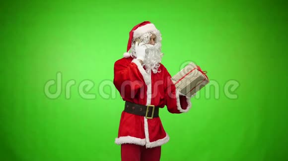 圣诞老人带着礼物在电话里讲话背景是绿色的视频的预览图