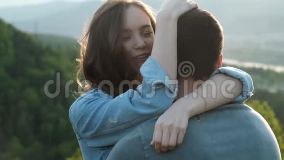 一个年轻女人在日落时轻轻地拥抱她的男朋友视频的预览图