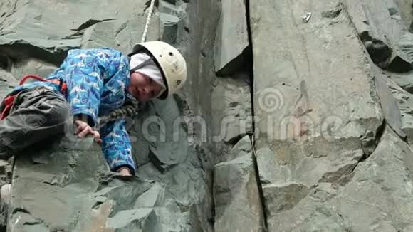 小男孩正在爬山年轻的运动员爬上一条攀岩道视频的预览图