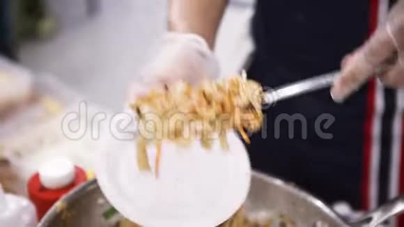 把亚洲面条放到一次性盘子里亚洲街头食品概念艺术烹饪厨师视频的预览图