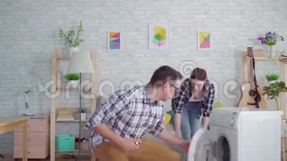 一对新婚夫妇正在用洗衣机做家务视频的预览图