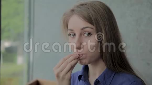 漂亮的女孩在快餐店吃炸土豆视频的预览图