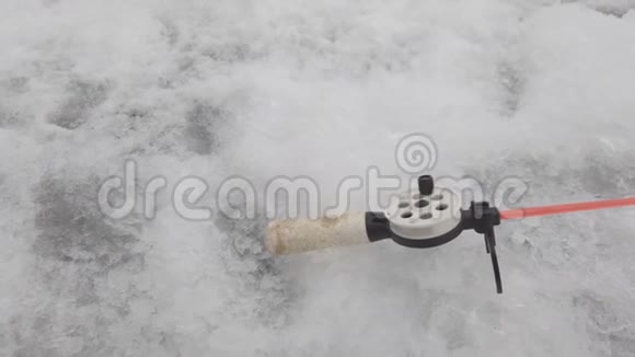 冰洞附近冬季捕鱼的钓竿视频的预览图
