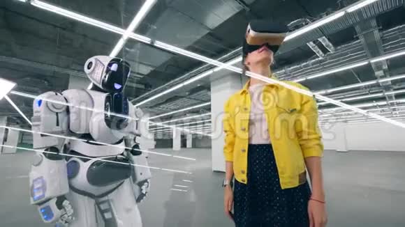 一个女孩在房间里使用VR眼镜触摸机器人的手视频的预览图