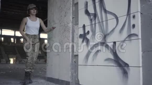 身着军装的年轻女子躲在尘土飞扬的肮脏废弃建筑里躲避敌人小女孩跑到镜头前视频的预览图