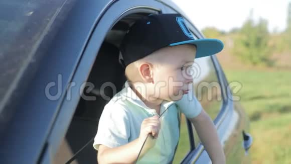 可爱的小男孩望着车窗外微笑旅行概念视频的预览图