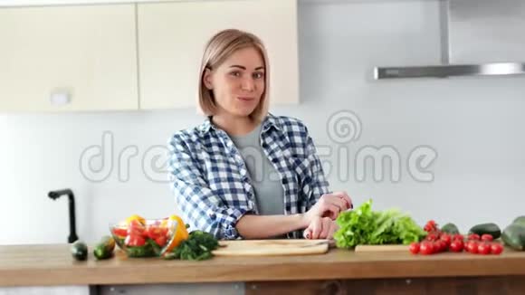 年轻女性在厨房中档的沙拉中食用新鲜的有机蔬菜视频的预览图