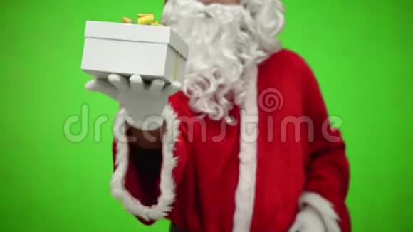 圣诞老人戴着手套的手拿着礼品盒绿色背景近点视频的预览图