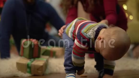 妈妈爸爸和小宝宝坐在房间的地板上装饰着圣诞节小孩子想走路视频的预览图