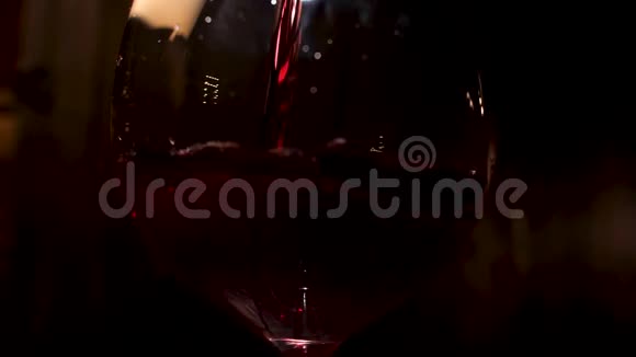 红酒倒在黑色背景的酒杯里库存录像把含酒精的饮料倒入视频的预览图