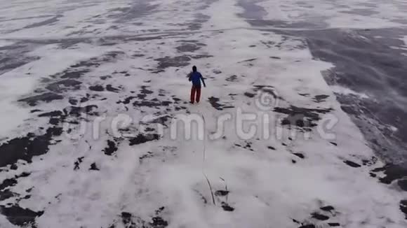 旅客在冰封的湖面上滑冰的鸟瞰图视频的预览图