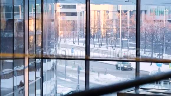 从商业建筑区的内部通过玻璃窗口在一个城市街道上的移动汽车库存数据视频的预览图