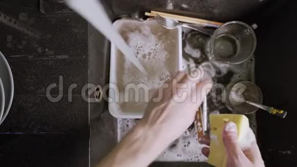 在黑色水槽里洗脏餐具视频的预览图