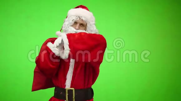 铬钥匙戴着白色手套的疲惫的圣诞老人肩上扛着一个带礼物的红色袋子视频的预览图