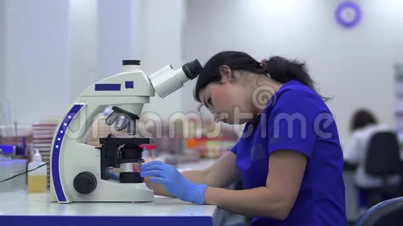年轻漂亮的女人在实验室里做分析在实验室进行研究通过视频的预览图