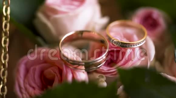 在一个装饰的盒子里合上一对结婚戒指里面有粉红色的嫩玫瑰花爱和家庭的概念行动视频的预览图