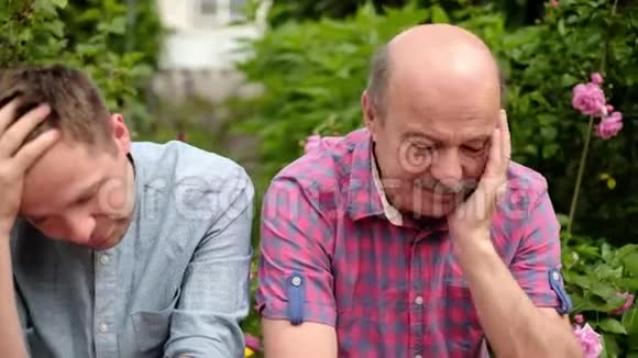 父亲和儿子坐在户外伤心被新闻弄得心烦意乱视频的预览图