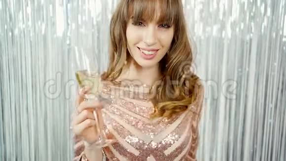 喜笑颜开的漂亮姑娘端着香槟庆祝新年视频的预览图