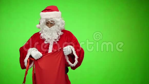 圣诞老人在彩色钥匙绿色屏幕上有礼品袋慢动作视频的预览图