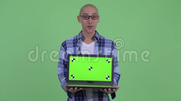 快乐的秃头嬉皮士展示笔记本电脑看上去很惊讶视频的预览图