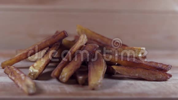 在炸薯条上加盐在木制背景下自制的炸薯条上放盐视频的预览图
