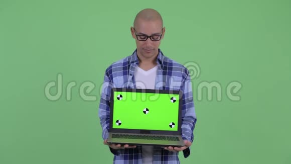 快乐的秃头嬉皮士一边思考一边展示笔记本电脑视频的预览图