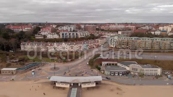 一个海上码头背景是建筑面积沙滩和白云下平静的海水的空中后景视频的预览图