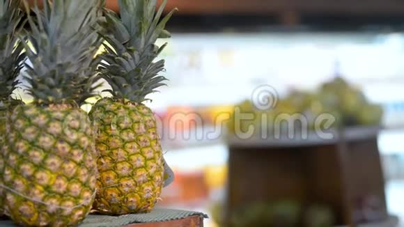年轻女性旅行者手里拿着异国情调的菠萝在亚洲超市视频的预览图