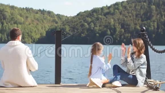 一家人带着一个小女孩在美丽的湖边钓鱼视频的预览图