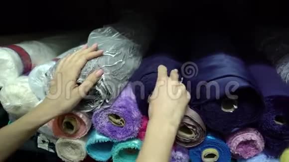 裁缝选用蓝缎面料从车间内的大堆中抽出视频的预览图