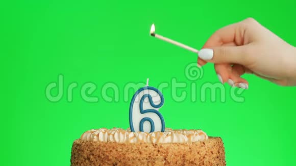 在一个美味的蛋糕上点燃和吹灭六号生日蜡烛绿色的屏幕视频的预览图