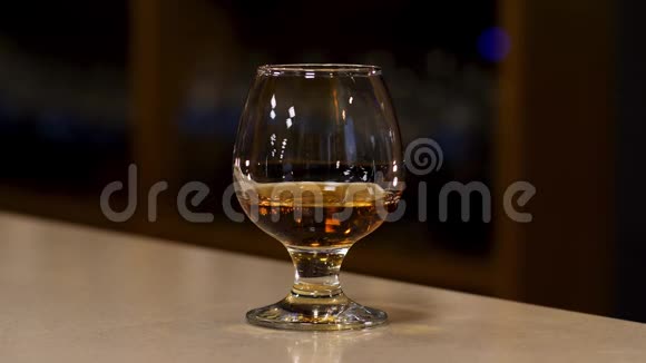 在酒吧柜台上放一杯白兰地白兰地或威士忌库存录像烈性酒视频的预览图