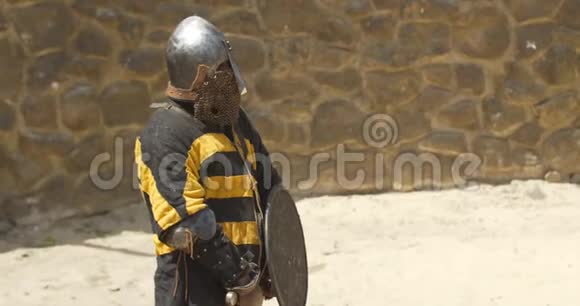 身穿盔甲手拿刀的战士站在竞技场的中央视频的预览图