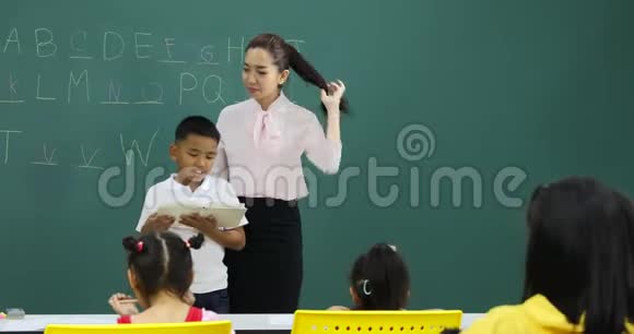 在英语课上亚洲男孩读一本书视频的预览图