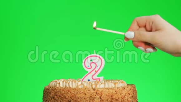 在美味的蛋糕上点燃2号生日蜡烛绿色屏幕2视频的预览图