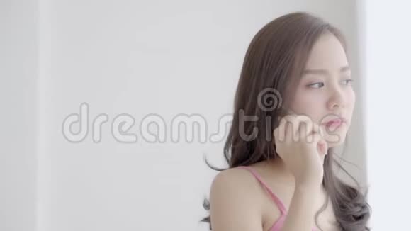 美丽的年轻亚洲女人站在卧室里有问题压力女孩使用手机智能手机视频的预览图