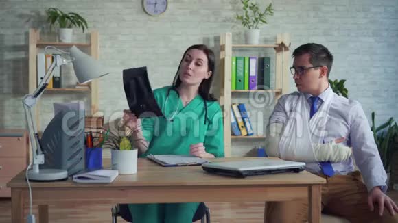手拿x光的女医生与病人沟通视频的预览图