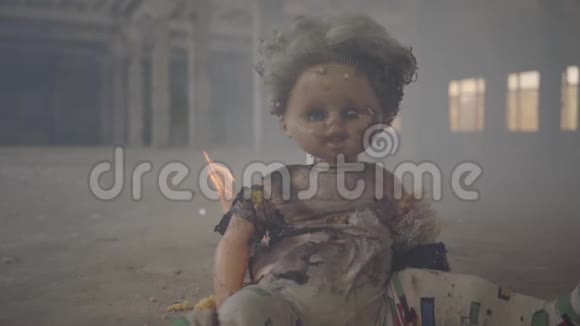 在一座废弃的烟雾弥漫的大楼里恐怖的洋娃娃在地板上燃烧火灾易燃性不符合视频的预览图