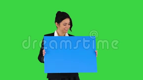 一个时尚的女人在绿色的屏幕上跳舞拿着空海报蓝色的模型视频的预览图