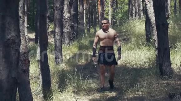 一个在森林里有两把斧头的野蛮人的慢镜头视频的预览图