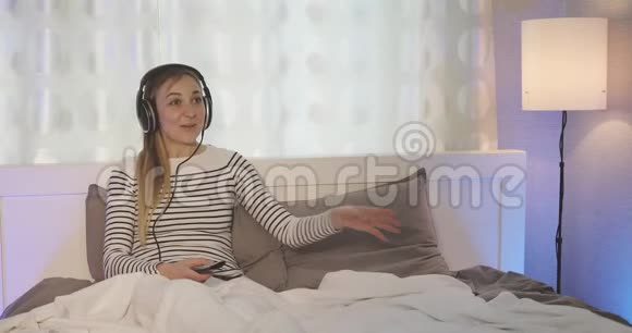 一个幸福的家庭戴着耳机听音乐的快乐女人视频的预览图