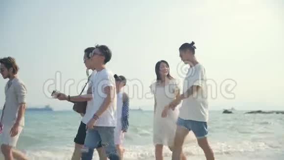 年轻的亚洲成年人在沙滩上唱歌的男男女女视频的预览图