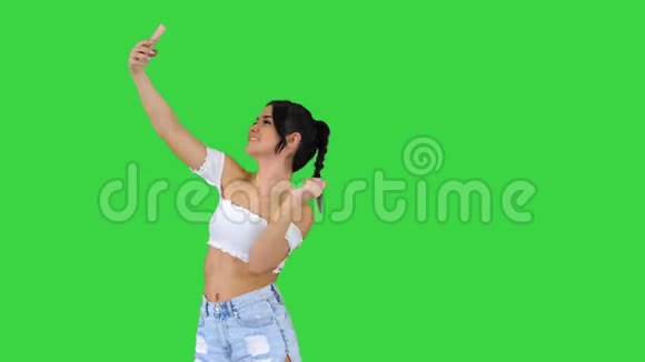 可爱的黑发女孩自拍和跳舞的绿色屏幕色度键视频的预览图