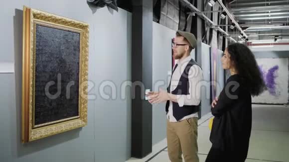 男人在美术馆表达他对图画的看法女人在倾听视频的预览图