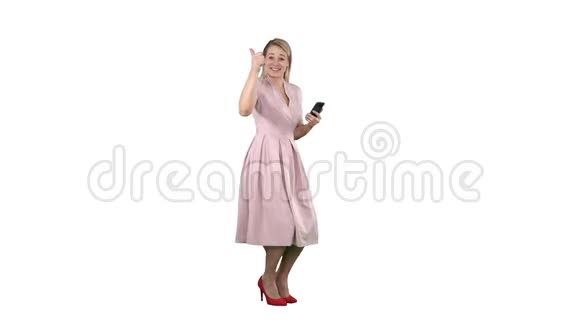 笑着站在白色背景上穿着粉红色裙子的漂亮年轻女人视频的预览图
