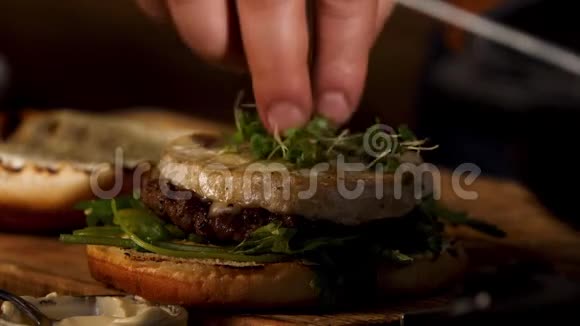 在自制汉堡加酱的camembert奶酪上抹上绿色的芥菜视频的预览图