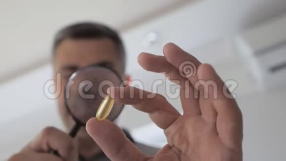一个人用放大镜胶囊检查药物视频的预览图
