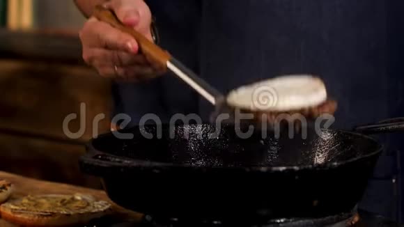 用金属铁铲将男性厨师用黑色铁锅从两边炸出的camembert奶酪库存数据视频的预览图