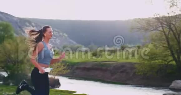 在大自然的神奇之处年轻的女士在山路上锻炼身体她很开心享受着时光视频的预览图