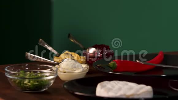 在绿色的墙壁背景上把不同的烹饪原料放在木桌上股票债券Chili视频的预览图
